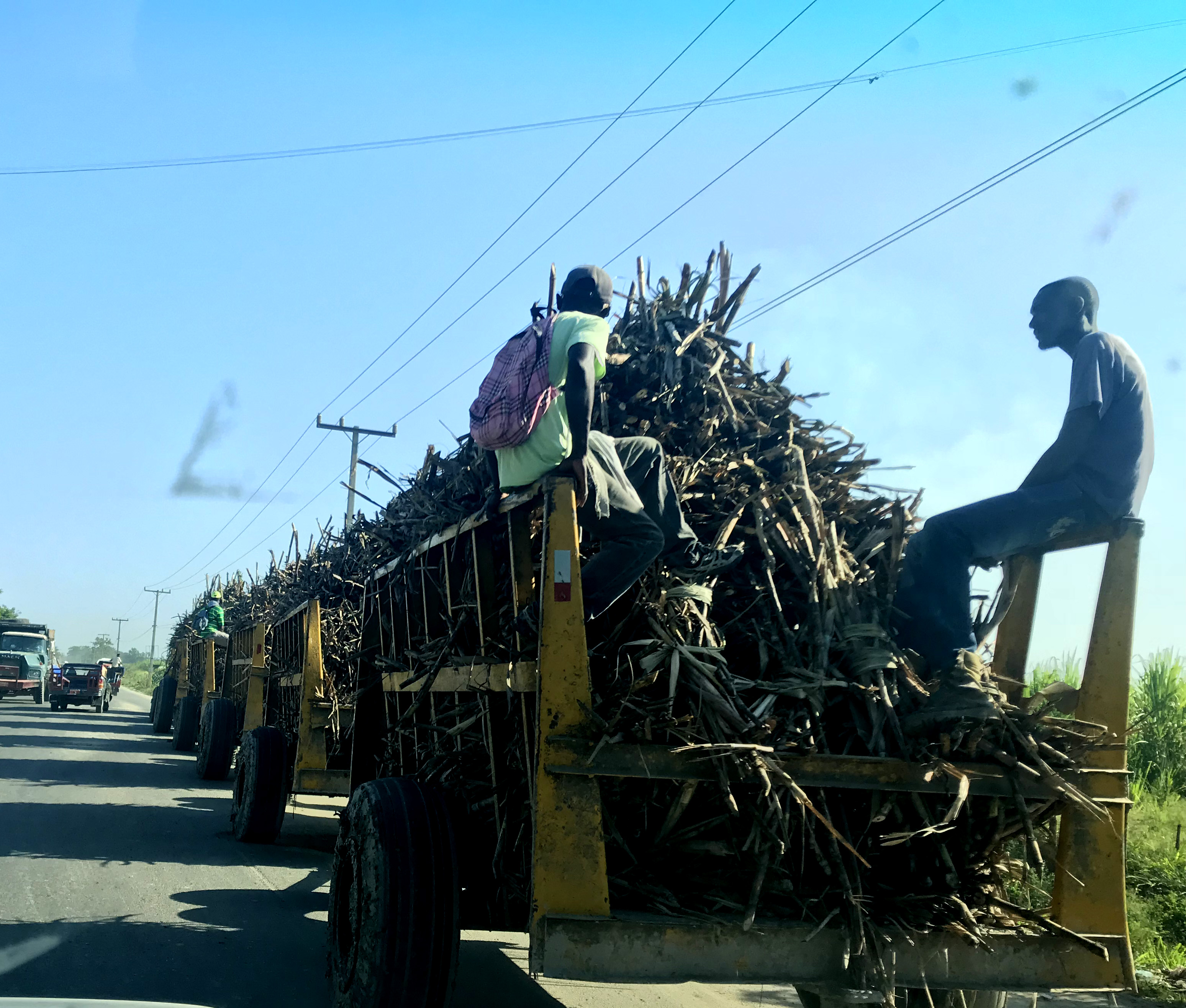 two Haitian men riding the cane train Haiti